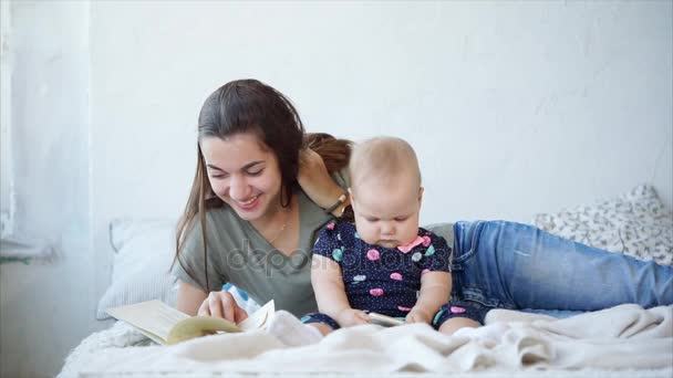 La mamma sta leggendo fiabe dal libro per il suo bambino in una camera da letto — Video Stock