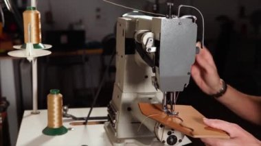 Usta için deri dikiş makinesi kullanıyor.