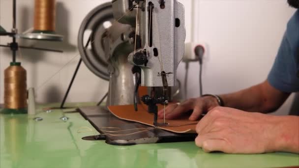 Mans hands working with sewing machine with leather. — Stock Video
