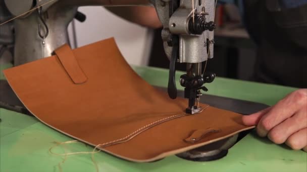 Close up shot of sewing machine, the master sews a leather purse in the workshop — Stock Video