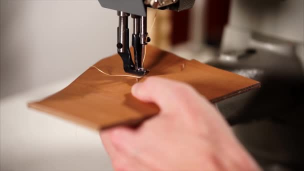 Close up tiro das mãos mestres, que coloca um pedaço de couro na máquina de costura — Vídeo de Stock