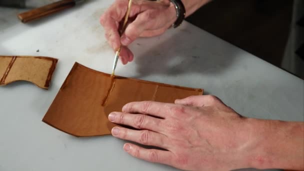 Close up shot of the master hands, who smears the piece from the piece of purse — Stock Video