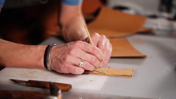 Craftsman puts glue on the leather with brush. — Stock Video