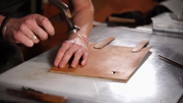 Close up of a craftsman working with leather using hammer — Stock Video