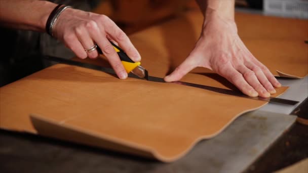 Cutting process of a handmade production accessories from leather, hands of man — Stock Video