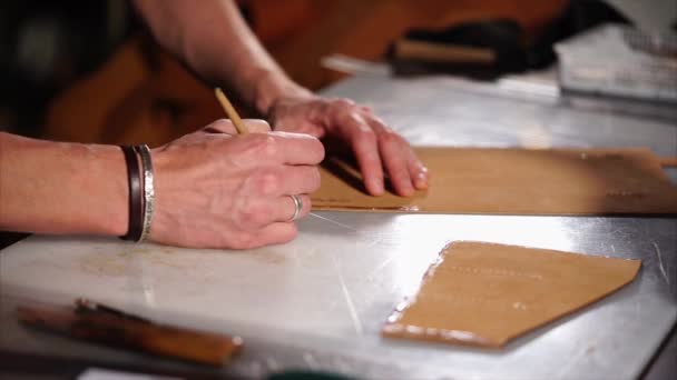 Artigiano sta spalmando adesivo sul bordo del dettaglio di taglio per borsa in pelle . — Video Stock