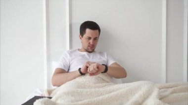 Adam uyanır ve smartwatch haberlerde denetler.