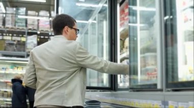 bir adam da buzdolabından yoğurt bir kavanoz alır, etikete benziyor