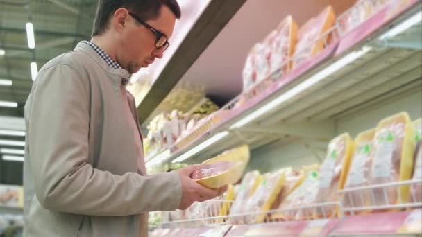 Hombre comprando carne de pollo en el supermercado — Vídeos de Stock