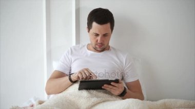 Adam yatakta yatarken Tablet Pc kullanma