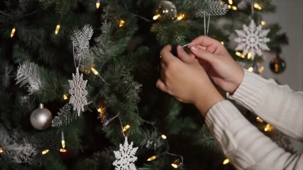 Γυναίκα που διακοσμεί χριστουγεννιάτικο δέντρο με ασημένια σφαίρα — Αρχείο Βίντεο