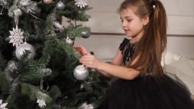 Noel ağacı süsleyen küçük kız