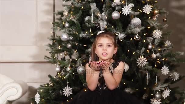 Petite fille soufflant des confettis à Noël — Video