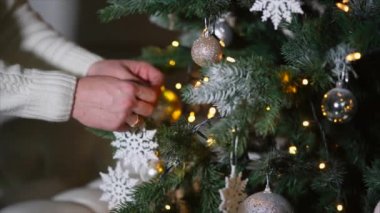 Adamın ellerini karanlık odada bir Noel ağacı üzerinde sahte beyaz kar-pul koyarak