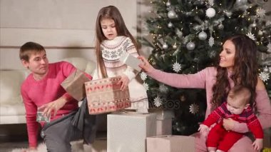 Mutlu dostu aile hediyeler büyük Noel ağacının altında katlama