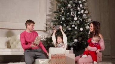 birbirlerine hediyeler Yılbaşı sırasında aile vermek onlar Noel ağacının yanında oturuyorlar