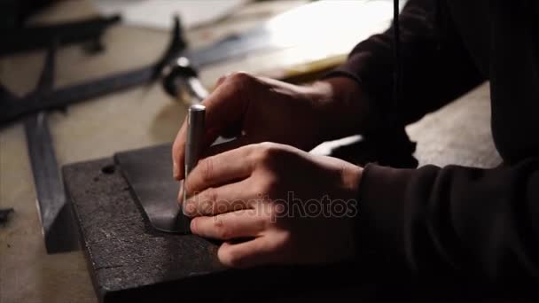 Skinner is making small holes in a blank of leather bag, made from black skin — Stock Video