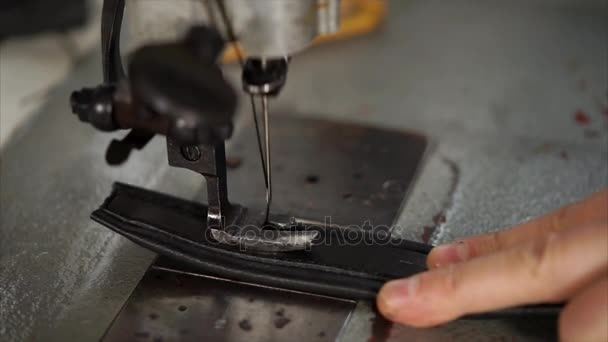 El hombre está trabajando en la máquina de coser con cuero . — Vídeos de Stock