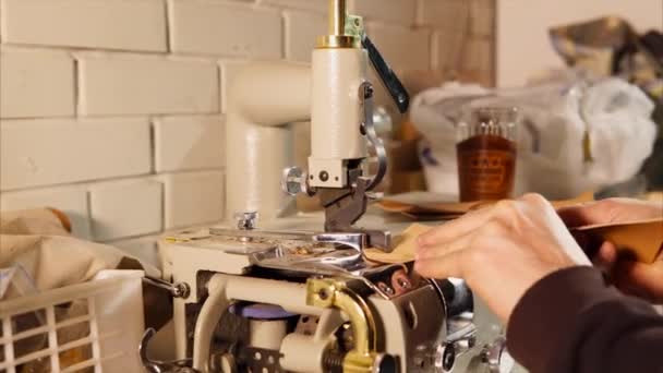 El hombre está utilizando una máquina especial para cortar el cuero . — Vídeos de Stock