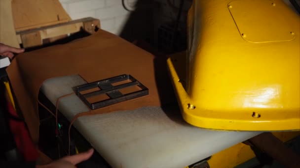 Таннер кладет фигурный нож на кожаный лист под автоматический пресс — стоковое видео