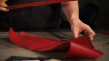 Leatherworker kırmızı boyalı deri şeritler Studio çalışma tablosu üzerinde kesme