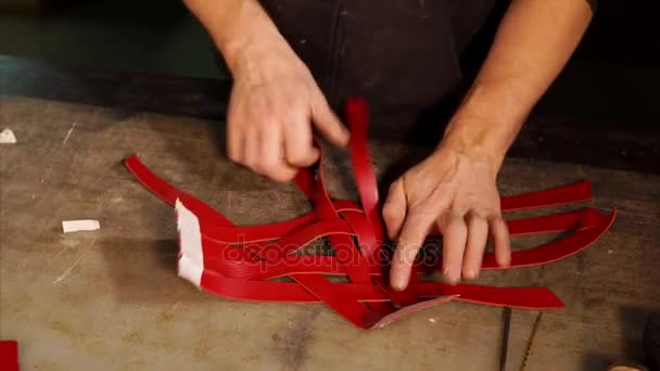 Professioneller Ledermeister arbeitet mit geflochtenen Lederstreifen. — Stockvideo