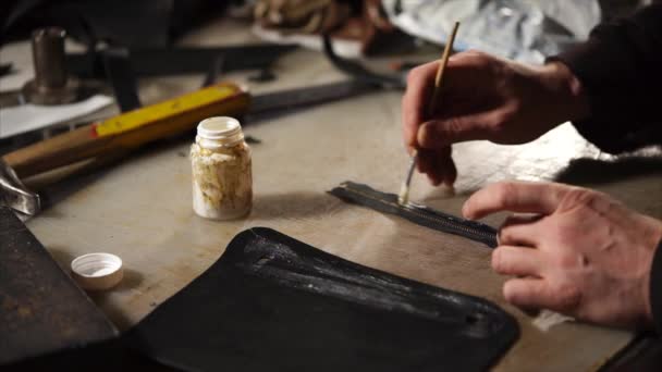 Läder hantverkare arbetar på en nya produkter vid bordet. — Stockvideo