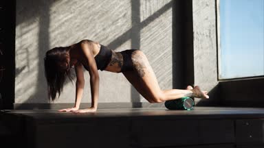kadın dövme olan bir silindir fitness club kasları ısınma için kullanır