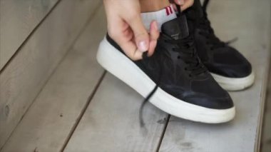 Kadının ayakları siyah spor ayakkabı ayakkabılı, ayakkabı bağcığı, yakın çekim el bağlama