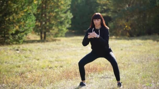 Aktivt liv med sport. Kvinnan har träning i höst park — Stockvideo