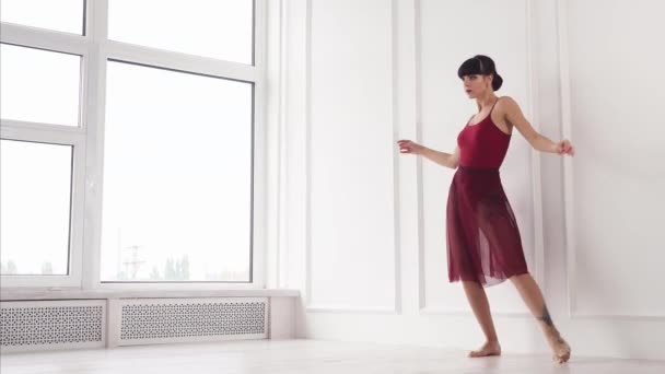 現代のバレリーナが情熱的に踊っているホールで白い壁の近く — ストック動画
