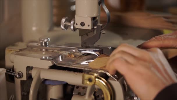 Close-up shot van de machine dat frames de randen van lederen stuk van materiaal — Stockvideo