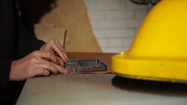 Close-up shot van een mans handen, die werkt met een machine en een lederen detail — Stockvideo