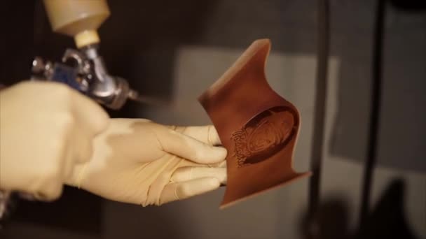 Coloring leather craftwork with spray — Stock Video