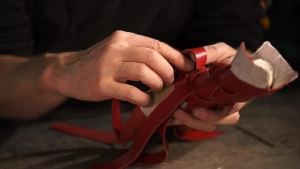 The process of weaving leather ropes and creating a sheath around the handmade — Stock Video