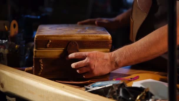 Чоловік відкриває старовинний шкіряний футляр зі старим грамофоном у темному лофт — стокове відео