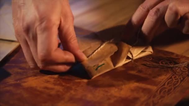 Man is tying a small paper bag with twine, package with handmade gifts — Stock Video