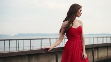 güzel kadının onun kırmızı elbise ve saç dalgalar serin Rüzgar