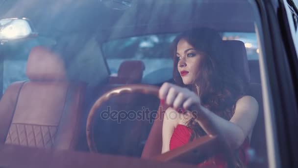 Mooie vrouw met make-up op haar gezicht is in de auto en kijkt naar de weg — Stockvideo