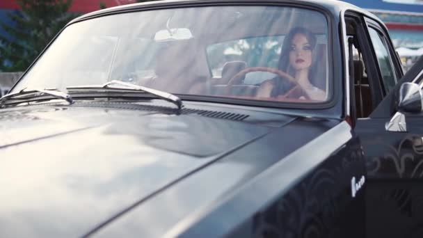 Chic woman sits behind the wheel of a vehicle, a lady has a lipstick on her lips — Stock Video