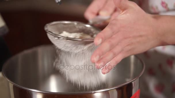 Close up shot of a womans hands, who sifts the flour through a sieve into mixer — Stock Video