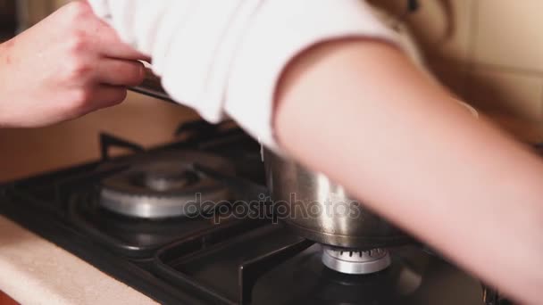 Kvinna kocken lägger socker från en plastmugg till en aluminiumkastrull över en eld — Stockvideo