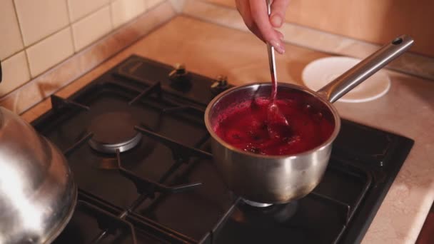 Γυναίκα ανάδευση χυμό μούρο στο τηγάνι. — Αρχείο Βίντεο