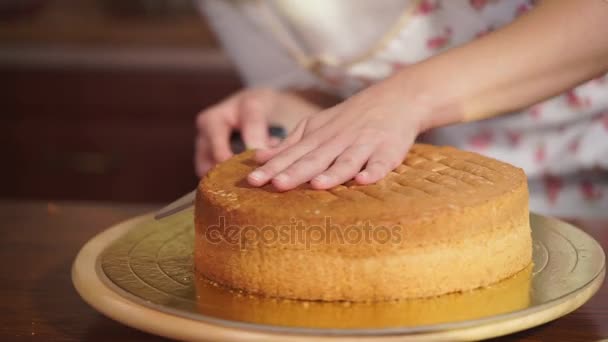 Жінка нарізає запечений торт на кухні — стокове відео