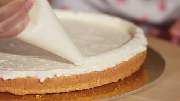 Vrouw trekt met een crème op een taart — Stockvideo