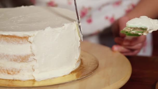 Menina está manchando lados bolo com um creme — Vídeo de Stock