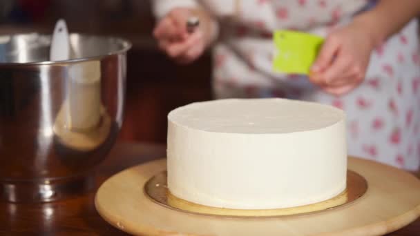 Крупним планом знімок кухарської руки, яка прикрашає торт кулінарним шпателем — стокове відео