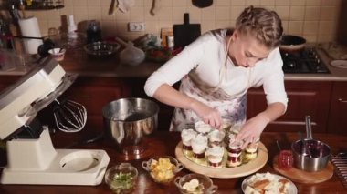 bir kadın bir mutfak önlük bir krem meyve ve çilek ile gözlük bırakır