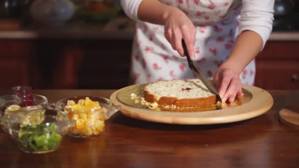 Close-up shot van de hand van de chef-koks die de taart in kleine stukjes voor het dessert snijdt — Stockvideo