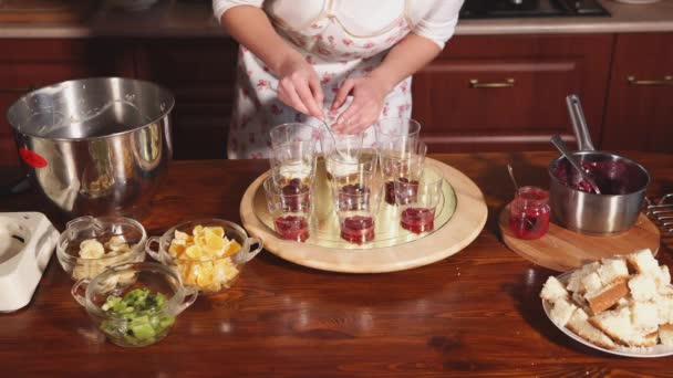 Die Köchin bereitet das Dessert zu, die Dame legt die Vanillecreme in die Tassen — Stockvideo